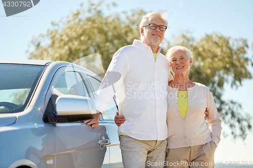 Image of happy senior couple hugging at car in summer