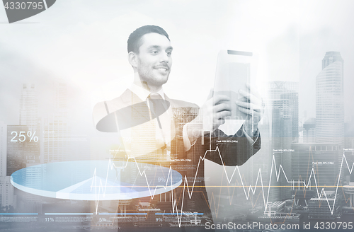 Image of businessman with tablet pc over city and charts