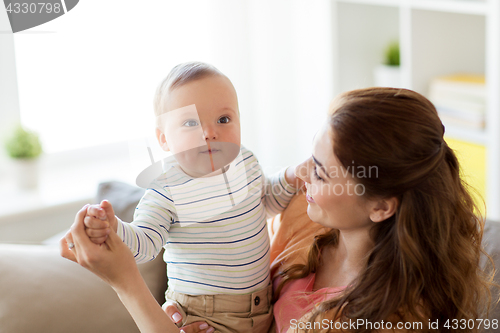 Image of happy young mother with little baby at home