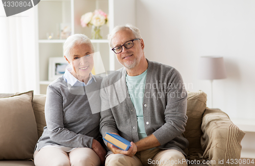 Image of happy senior couple sitting on sofa at home