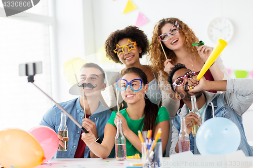 Image of happy team taking selfie at office party