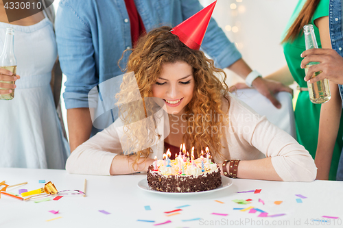 Image of happy woman with birthday cake at home party