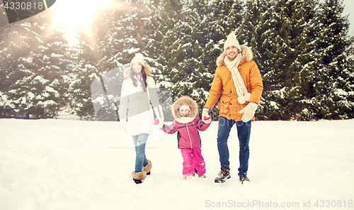 Image of happy family in winter clothes walking outdoors