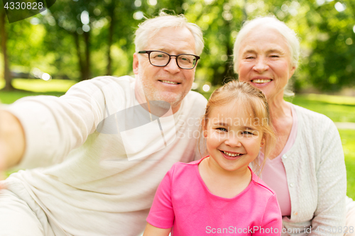 Image of senior grandparents and granddaughter selfie