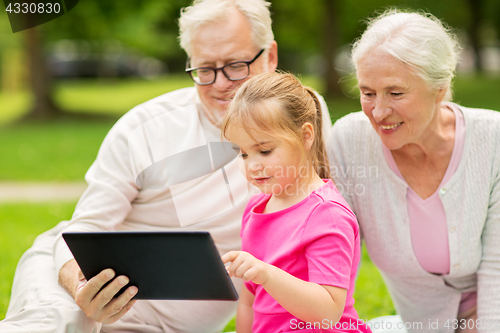 Image of grandparents and granddaughter with tablet pc