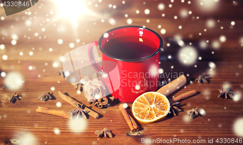 Image of close up of tea cup with spices on wooden table