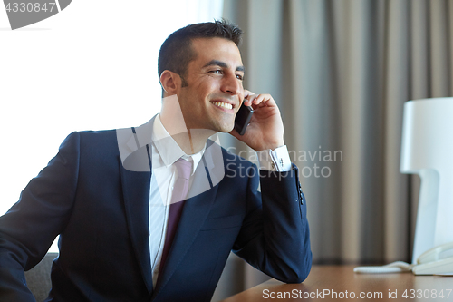 Image of businessman calling on smartphone at hotel room