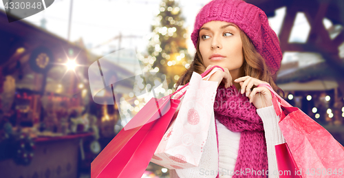 Image of happy woman with shopping bags over christmas fair