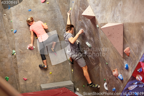 Image of man and woman training at indoor climbing gym wall