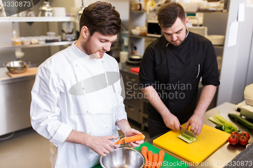 Image of chef and cook cooking food at restaurant kitchen