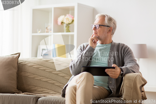 Image of senior man with tablet pc sitting on sofa at home