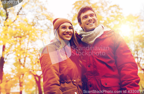 Image of happy young couple walking in autumn park