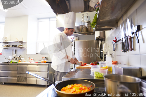 Image of male chef cooking food at restaurant kitchen