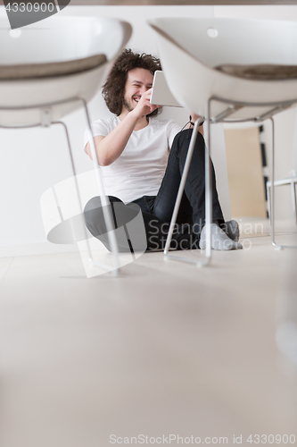 Image of young man using a tablet at home