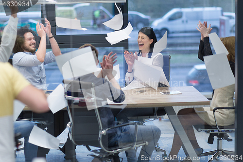 Image of startup Group of young business people throwing documents