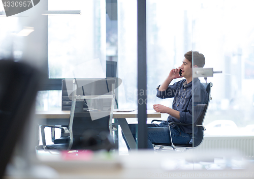 Image of Young casual businessman using smartphone