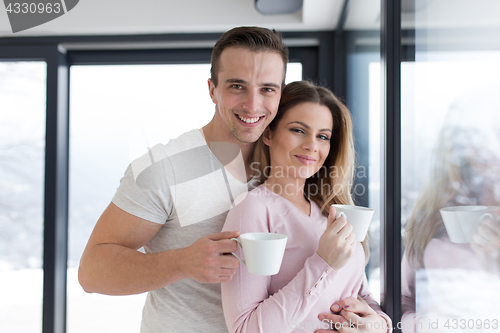 Image of young couple enjoying morning coffee by the window