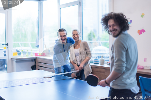 Image of startup business team playing ping pong tennis