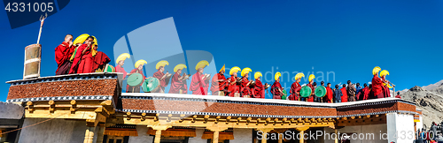 Image of Monks in row on roof in Ladakh