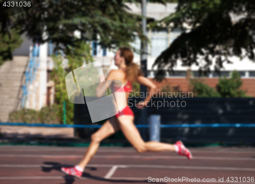Image of Blurred view of running girl at stadium not in focus