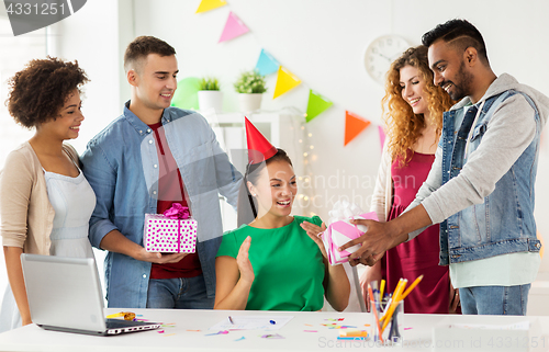 Image of team greeting colleague at office birthday party