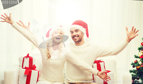 Image of happy couple at home with christmas gift boxes