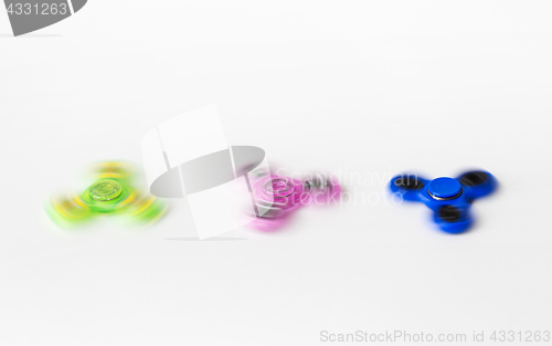 Image of three spinning fidget spinners on white background