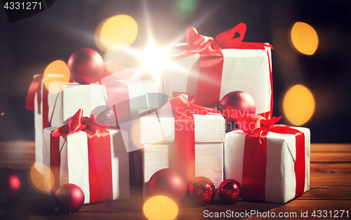 Image of gift boxes and red christmas balls on wooden floor