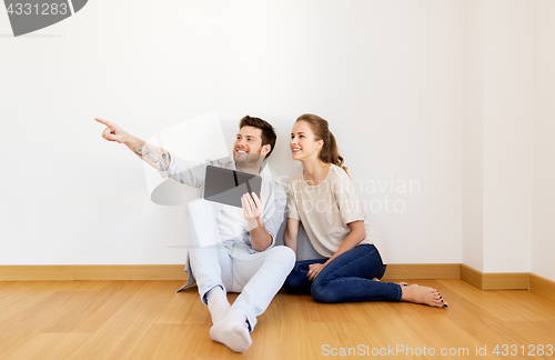 Image of happy couple with tablet pc computer at new home