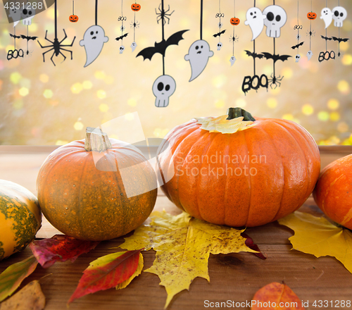Image of pumpkins with autumn leaves and halloween garland