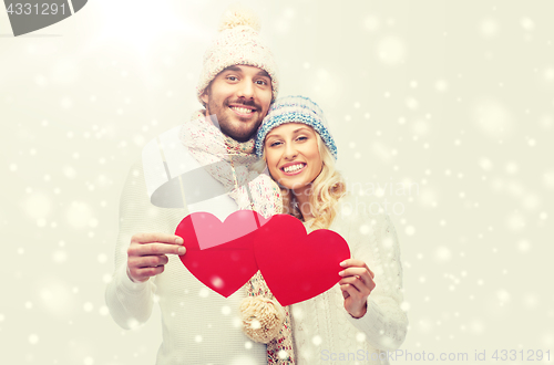 Image of smiling couple in winter clothes with red hearts