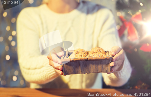 Image of close up of woman with oat cookies at home