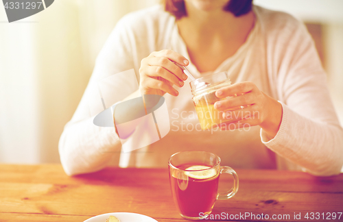 Image of close up of ill woman drinking tea with honey