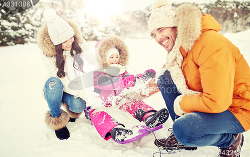 Image of happy family with kid on sled having fun outdoors