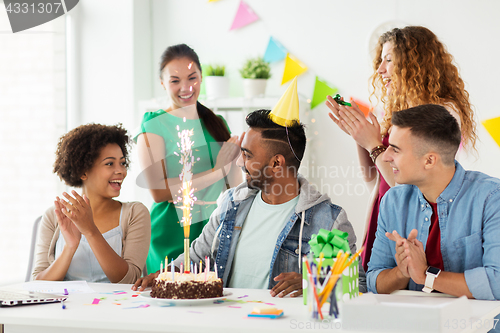 Image of team greeting colleague at office birthday party
