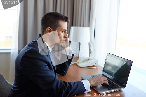 Image of businessman with laptop and smartphone at hotel