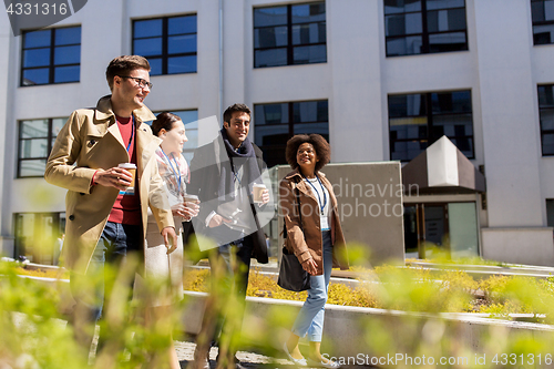 Image of people with coffee and conference badges in city