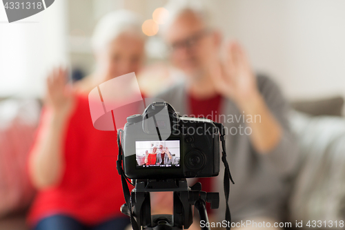 Image of happy senior couple with camera recording video