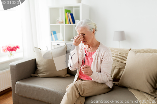 Image of senior woman with glasses having headache at home