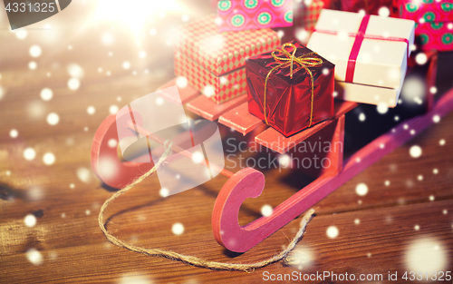 Image of close up of christmas gift boxes on wooden sleigh