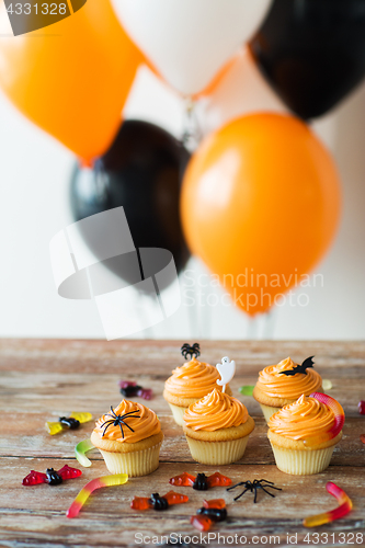 Image of halloween party cupcakes and candies on table