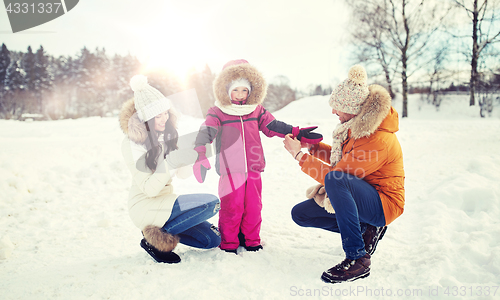 Image of happy family with child in winter clothes outdoors