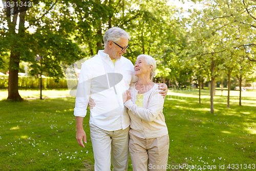 Image of happy senior couple hugging in city park