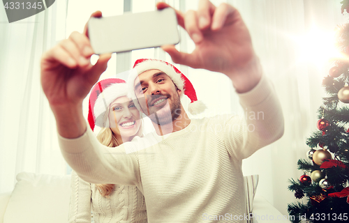 Image of couple taking selfie with smartphone at christmas