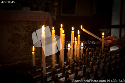 Image of Woman lighting prayer candle