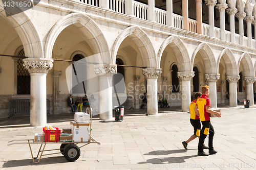 Image of DHL Postmen delivering parcels on the Piazza San Marco in Venice