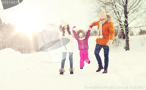 Image of happy family in winter clothes walking outdoors