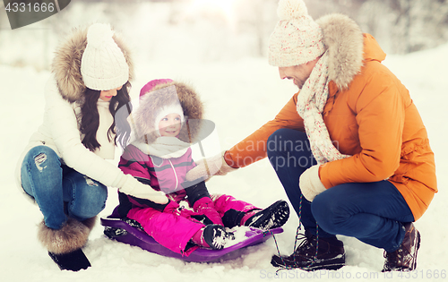 Image of happy family with sled walking in winter forest