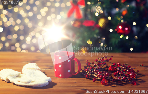 Image of tea cup with mittens and christmas decoration