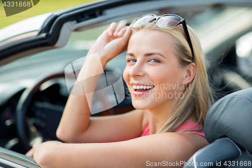 Image of happy young woman in convertible car